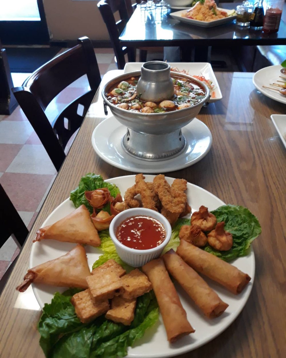 Seafood hot pot and appetizer combination plate on a table inside Thai Star